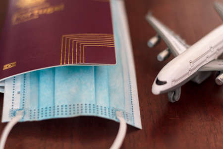 Passport with protective mask and airplane. Concept of Traveling during coronavirus, covid-19 pandemicの写真素材