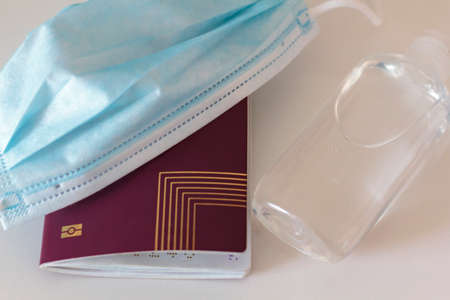 Passport, medical face mask and hand sanitizer. Concept of Traveling during coronavirus, covid-19 pandemicの写真素材