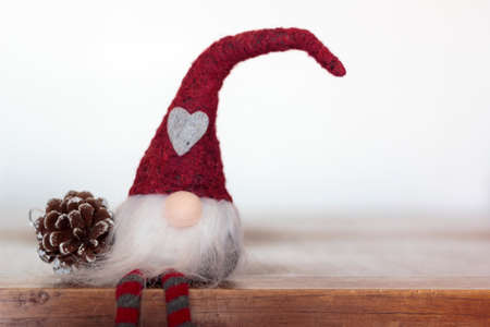 Christmas gnome and pine cone on wooden table with copy spaceの写真素材