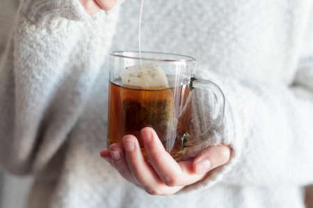 Woman hands dipping tea bag in hot wateの写真素材