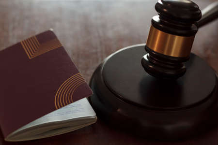 Judge's gavel and passport on wooden table. Concept of international law, immigration law and citizenship rightsの写真素材