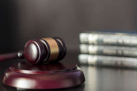 Judge's gavel on black table with law books on the background. Law and justice conceptの写真素材