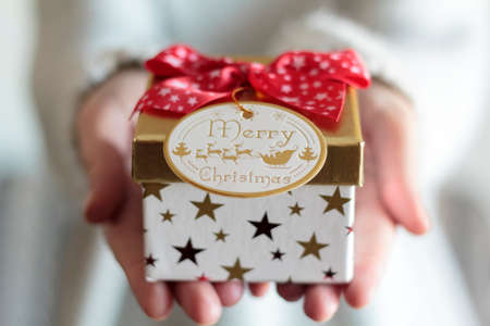 Woman hands holding a christmas gift boxの写真素材