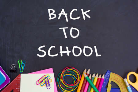 Top view of school supplies with Back to School text on chalkboardの写真素材