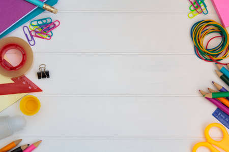 School supplies on side borders on white wooden table. Top view with copy space. Back to school conceptの写真素材