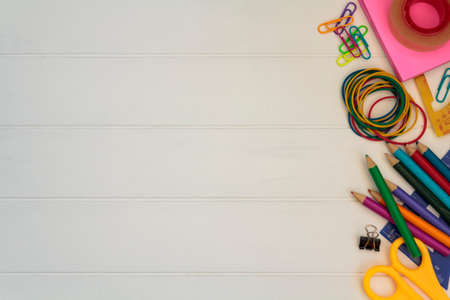 School supplies side border on white wooden table. Top view with copy space. Back to school conceptの写真素材