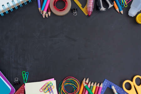 School supplies on chalkboard with copy space in the middle. Back to school conceptの写真素材