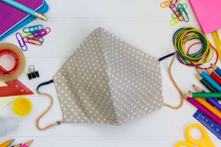 Top view of school supplies and protective mask. Back to school during covid-19 pandemic, new normal conceptの写真素材