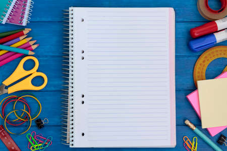 Top view of school supplies and notebook with blank space on blue wooden table. Back to school conceptの写真素材