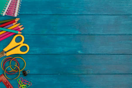 School supplies on side border on blue wooden table. Top view with copy space. Back to school conceptの写真素材