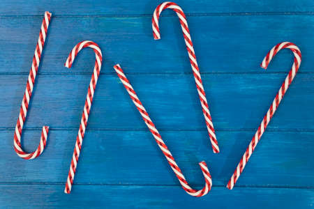 Top view of candy canes on blue wooden table. Top view, flat layの写真素材