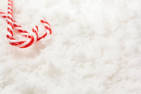 Candy canes on snow with copy space. Winter, Christmas background