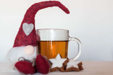 Christmas gnome with tea and star-shaped cookiesの写真素材