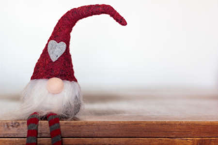 Christmas gnome sitting on wooden table with copy spaceの写真素材