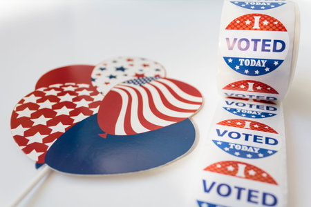 Roll of I Voted Today stickers and USA balloons on white background. US election concept
