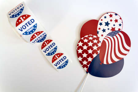 Roll of I Voted Today stickers and USA balloons on white background. US presidential election conceptの写真素材