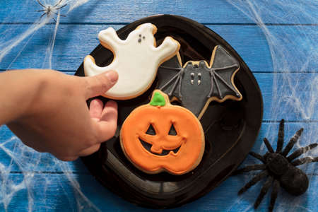 Top view of woman's hand holding halloween biscuitの写真素材