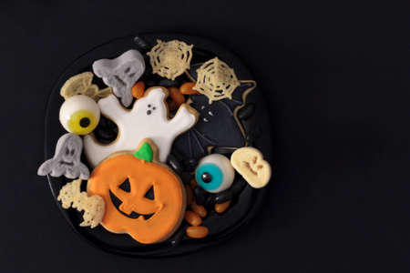 Top view of plate full of Halloween treats. Black background with copy spaceの写真素材