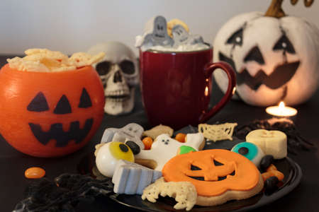 Halloween table with spooky treats and snacks, hot drink and scary decorationの写真素材
