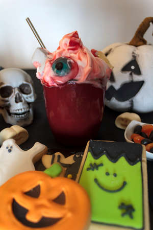 Delicious halloween drink on table with treats and snacksの写真素材