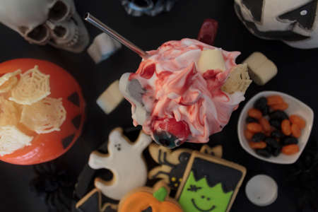 Top view of delicious halloween drink on table with treats and snacksの写真素材