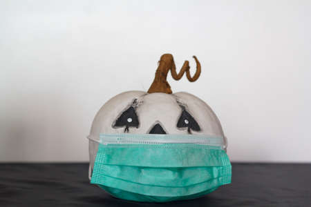 Pumpkin with protective face mask. Concept of halloween during covid-19 pandemicの写真素材
