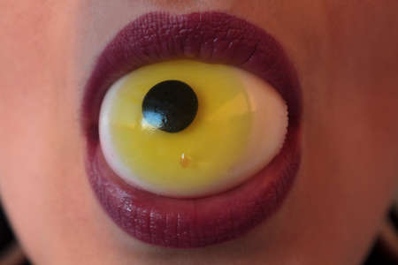 Close-up of woman with eyeball on the mouth. Halloween conceptの写真素材