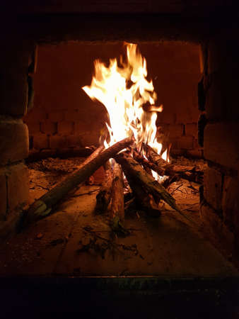 Wood-fired oven with burning wood insideの写真素材