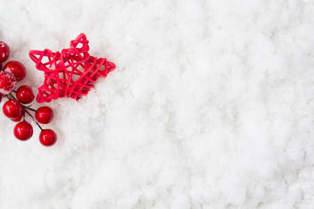 Holly berries and star on snow with copy space. Winter holiday, christmas backgroundの写真素材