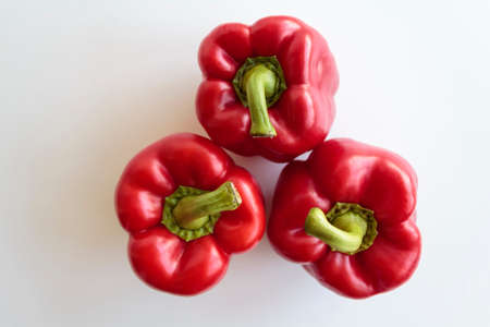 Top view of three red peppers on white backgroundの写真素材
