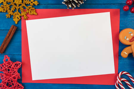 Top view of christmas decoration and blank card with copy space on blue wooden tableの写真素材