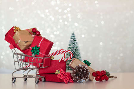 Chrismtas background with wrapped gifts on shopping cart and christmas decoration. With copy spaceの写真素材