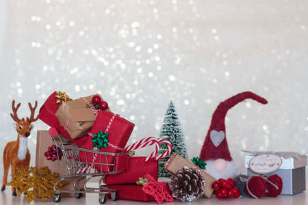 Chistmas background with wrapped gifts, christmas tree, reindeer, pine cone, shopping cart and christmas elf. With copy spaceの写真素材
