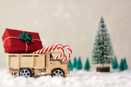 Christmas truck with gift or present on snowy road with christmas trees on the backgroundの写真素材