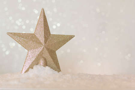 Christmas golden star on shiny bokeh background with copy spaceの写真素材