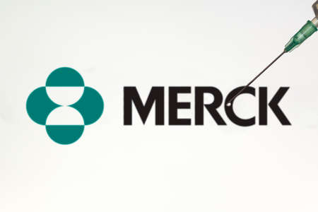 Lisbon, Portugal - November 22, 2020: Syringe and Merck logo on the background. Coronavirus, Covid-19 vaccine conceptのeditorial素材