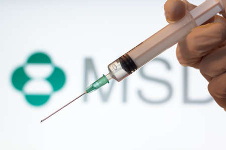 Lisbon, Portugal - November 22, 2020: Syringe and MSD logo on the background. Coronavirus, Covid-19 vaccine conceptのeditorial素材