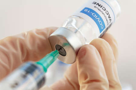 Doctor hand preparing Covid-19 Coronavirus vaccineの写真素材