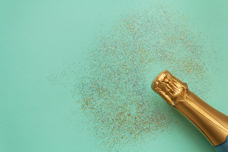 Top view of Golden champagne bottle and glitter on blue background with copy space. Celebration conceptの写真素材