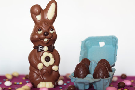 Easter chocolate bunny and egg carton with chocolate eggs against white backgroundの写真素材