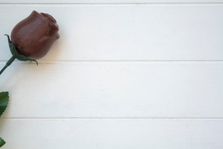 Chocolate rose on white wooden table with copy space. Valentines day conceptの写真素材