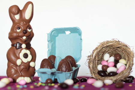 Chocolate bunny, egg carton with chocolate eggs and bird nest with sweet almondsの写真素材