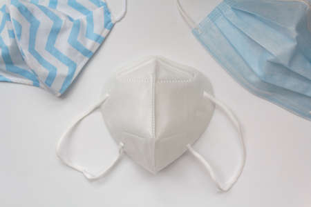 Kn95 mask on center and cloth mask and surgical mask on the corners.の写真素材