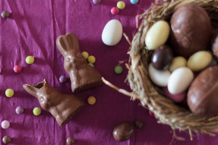 Top view of chocolate bunnies and nest with easter eggsの写真素材