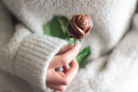 Woman hands holding chocolate rose. Valentine's day conceptの写真素材