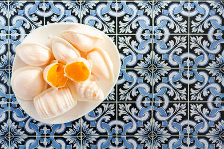 Typical portuguese sweet called Ovos Moles de Aveiro on portuguese tiles background. Top view with copy spaceの写真素材