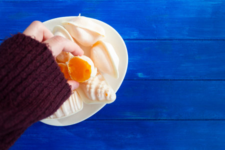 Top view woman hand taking a traditional portuguese sweet called Ovos Moles de Aveiroの写真素材