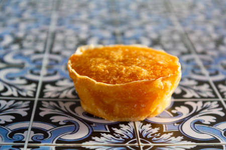 Traditional portuguese sweet bean pastry called Pastel de Feijao on portuguese tiles backgroundの写真素材