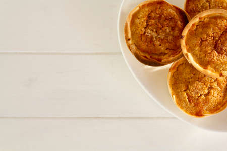 Top view of Traditional Portuguese chessecakes called Queijada de Sintra on white wooden table with copy spaceの写真素材