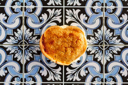 Top view of portuguese cheesecake called Queijada de Sintra on portuguese tiles backgroundの写真素材
